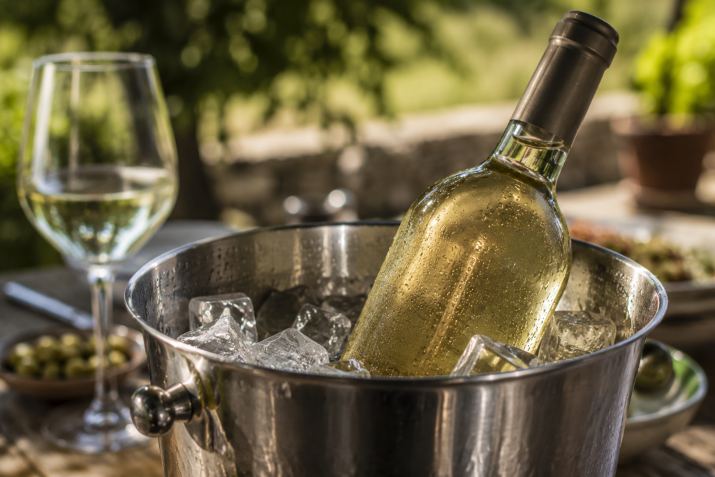 Garrafa de vinho branco de verão a refrescar em balde de gelo, ilustrando o artigo "Vinhos de Verão Não São Vinhos Menores".